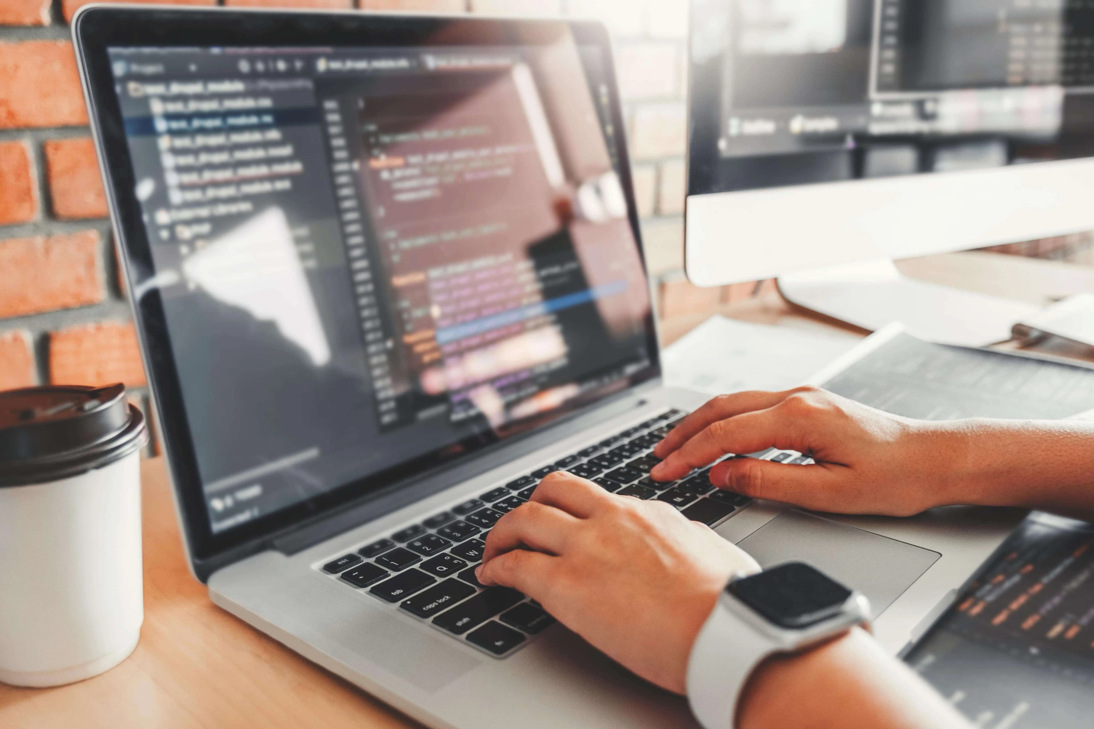 Programista walidujący system cyfrowy, pracujący na laptopie